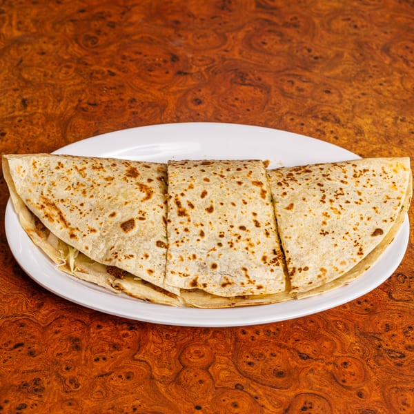 Three large, folded quesadillas with browned tortillas and filling, served on a white plate.