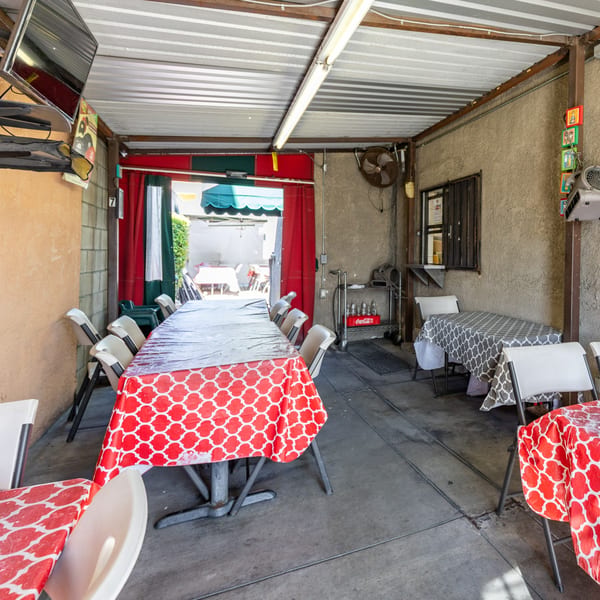 Outdoor patio dining area at Little Mexico Chiquito with red and white patterned tablecloths.