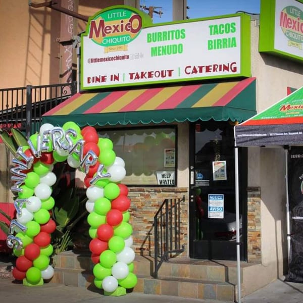 Little Mexico Chiquito restaurant exterior with a colorful awning and an 'Anniversary' balloon arch.